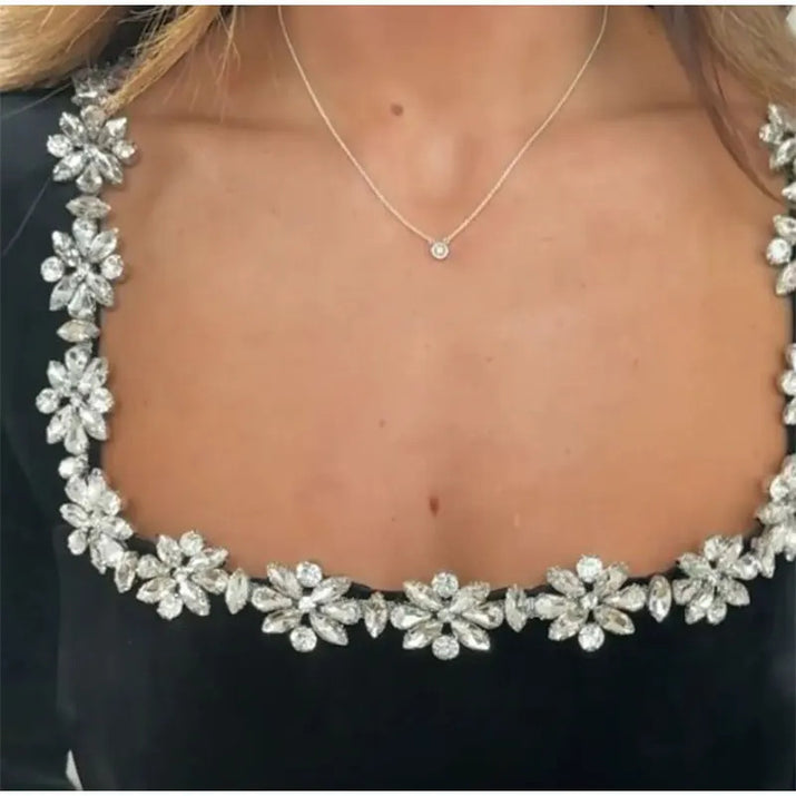 detailed close up of sparkly jewel trim on black velvet christmas dress