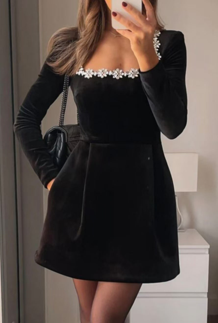Black velvet Christmas party dress with jeweled neckline and long sleeves.