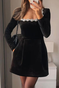Black velvet Christmas party dress with jeweled neckline and long sleeves.