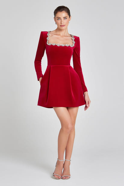 Elegant red velvet Christmas party dress with rhinestone neckline, long sleeves, and flared skirt, styled for holiday events.